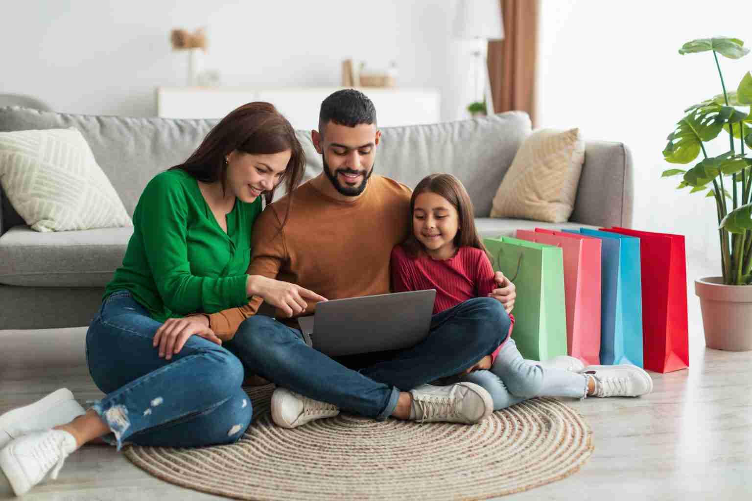 Happy Arab family using laptop in living room